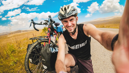 Caucasian male person takes selfie on bicycle vacation in scenic caucasus armenia mountains region....