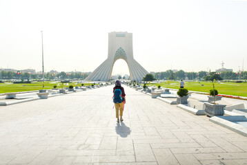 13th june, 2022: backpacker woman walk by Azadi tower - famous landmark in Tehran in capital of...