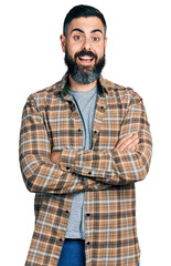 Hispanic man with beard with arms crossed gesture celebrating crazy and amazed for success with open eyes screaming excited.