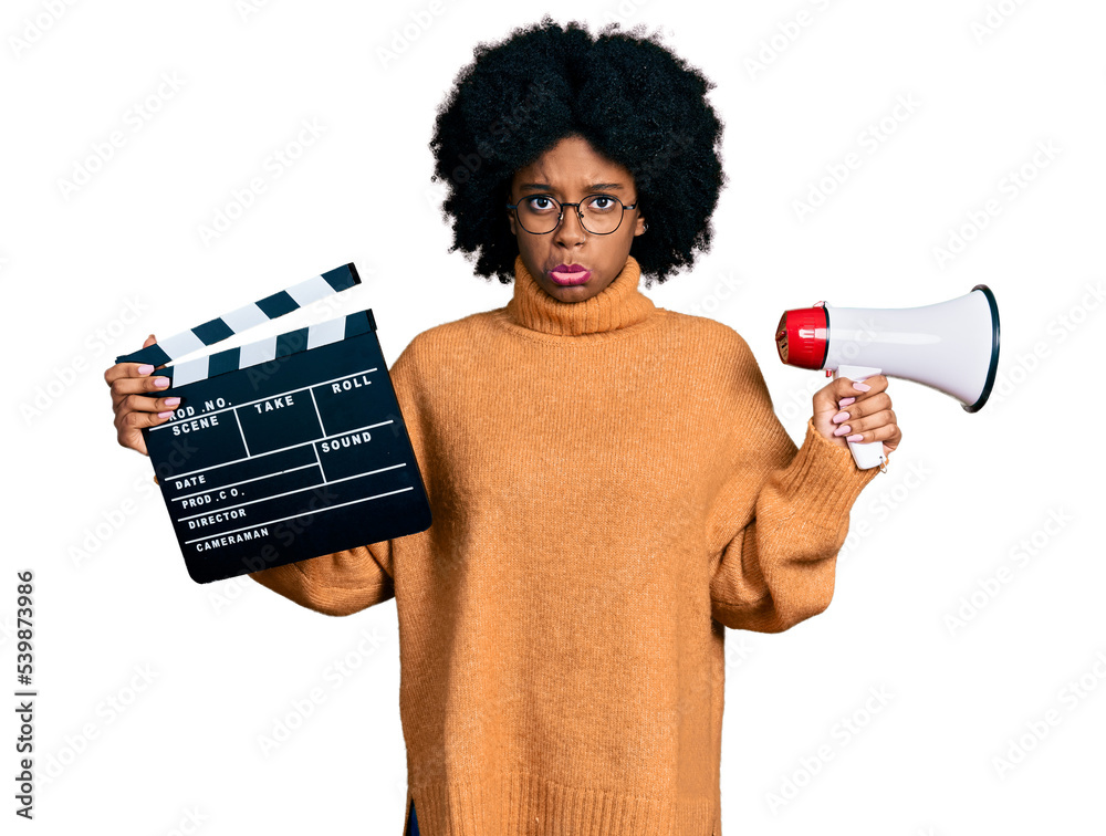 Poster young african american woman holding video film clapboard and megaphone depressed and worry for dist