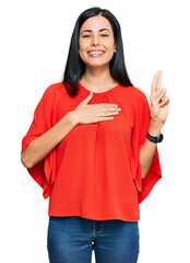 Beautiful young woman wearing casual clothes smiling swearing with hand on chest and fingers up,...
