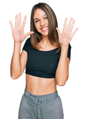 Young brunette woman wearing casual clothes showing and pointing up with fingers number ten while smiling confident and happy.