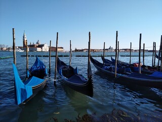 Row of gondolas moored on the pier of the water in Venice, Italy
