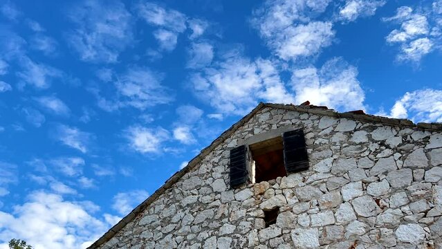 Time-lapse of a cloudscape with a stone house in Croatia