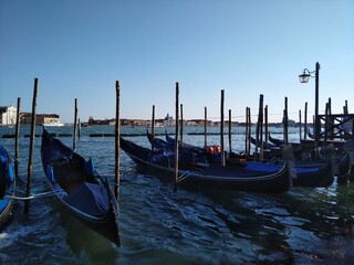 Row of gondolas moored on the pier of the water in Venice, Italy