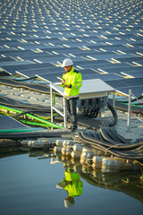 Portrait of professional man engineer working checking the panels at solar energy on buoy floating. Power plant with water, renewable energy source. Eco technology for electric power in industry.