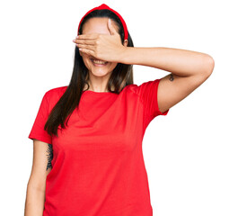 Young hispanic woman wearing casual clothes smiling and laughing with hand on face covering eyes for surprise. blind concept.