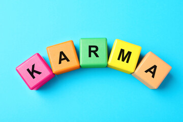 Word Karma made of colorful cubes with letters on light blue background, top view