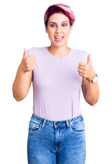 Young beautiful woman with pink hair wearing casual clothes success sign doing positive gesture with hand, thumbs up smiling and happy. cheerful expression and winner gesture.