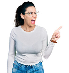 Young hispanic woman pointing with fingers to the side angry and mad screaming frustrated and furious, shouting with anger. rage and aggressive concept.
