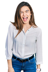 Young caucasian girl wearing casual white shirt winking looking at the camera with sexy expression, cheerful and happy face.