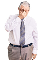 Senior grey-haired man wearing business clothes tired rubbing nose and eyes feeling fatigue and...