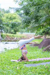 A beautiful young girl doing yoga in the park in the morning., peace and relaxation, woman's happiness