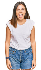 Obraz premium Young caucasian woman wearing casual white tshirt sticking tongue out happy with funny expression. emotion concept.