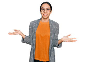 Young hispanic girl wearing business jacket and glasses clueless and confused expression with arms and hands raised. doubt concept.