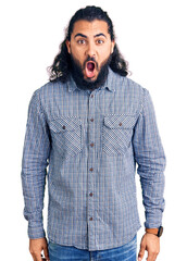 Young arab man wearing casual clothes afraid and shocked with surprise and amazed expression, fear and excited face.