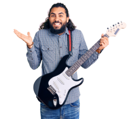 Young arab man playing electric guitar celebrating victory with happy smile and winner expression with raised hands