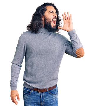 Young arab man wearing casual clothes shouting and screaming loud to side with hand on mouth. communication concept.
