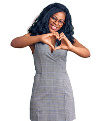 Beautiful african american woman wearing business dress and glasses smiling in love showing heart symbol and shape with hands. romantic concept.