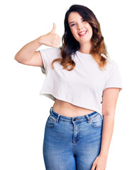 Obraz premium Beautiful young brunette woman wearing casual clothes smiling happy and positive, thumb up doing excellent and approval sign