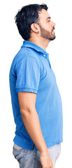 Young hispanic man wearing casual clothes looking to side, relax profile pose with natural face with confident smile.