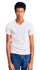 Young african american man wearing casual white t shirt with serious expression on face. simple and natural looking at the camera.