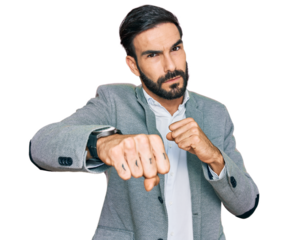 Young hispanic man wearing business clothes punching fist to fight, aggressive and angry attack, threat and violence