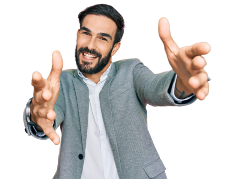 Young hispanic man wearing business clothes looking at the camera smiling with open arms for hug. cheerful expression embracing happiness.