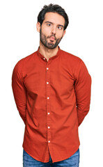 Young hispanic man wearing casual clothes making fish face with lips, crazy and comical gesture. funny expression.