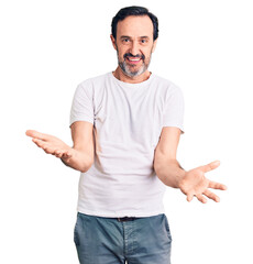 Middle age handsome man wearing casual t-shirt smiling cheerful with open arms as friendly welcome, positive and confident greetings