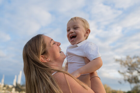 lesbian mother lifting child into air and laughing
