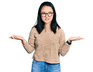 Young chinese woman wearing casual sweater and glasses clueless and confused with open arms, no...