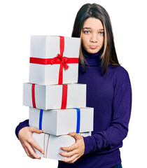 Young brunette girl with long hair holding gifts depressed and worry for distress, crying angry and afraid. sad expression.