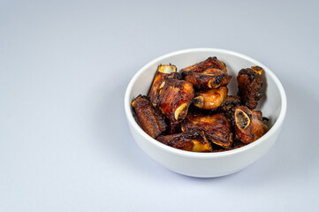 Grilled pork ribs in a bowl with white background,  Obesity causes, Cancer causes, Unhealthy food.