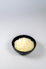 Top view of Rice in a black bowl on a white background, Copy space for text.