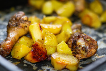 Defocus roasted chicken leg with potatoes cumin and garlic. Roasted chicken in sauce with potatoes. Close up. Copy space. Out of focus