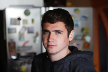 Defocus portrait young man indoors background. Serious young man with blue eyes. 20s years. Handsome man outdoors portrait. Lifestyle. Student. Closeup. Out of focus