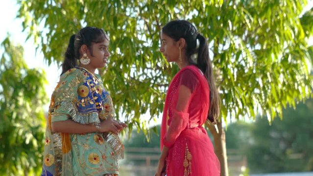 Portrait of beautiful indian girls. Young hindu woman model. Traditional India costume lehenga choli for Navaratri. young beautiful indian girl on green background. girls talking