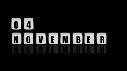 November 4th. Day 4 of month, Calendar date. White cubes with text on black background with reflection. Autumn month, day of year concept