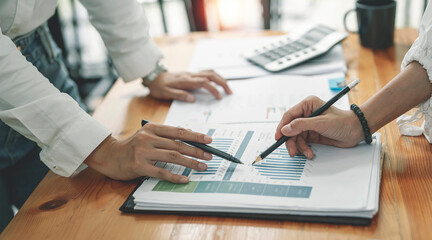 Business women discuss to working with graph chart and using laptop and for searching information stock market