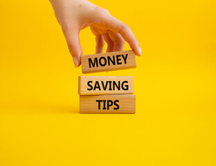 Money saving tips symbol. Concept words Money saving tips on wooden blocks. Beautiful yellow...