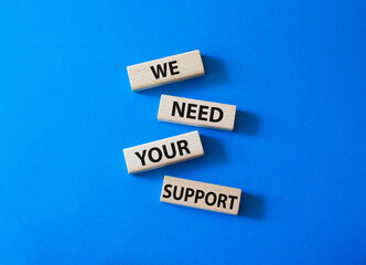 We need your support symbol. Wooden blocks with words We need your support. Beautiful blue background. Business and We need your support concept. Copy space.