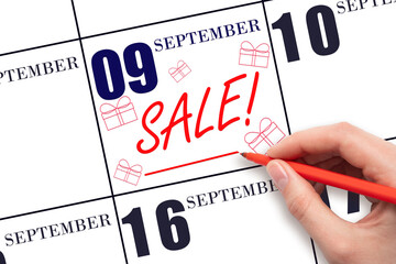 Hand writing text SALE and drawing gift boxes on calendar date September 9. Shopping Reminder