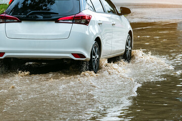 Car passing through a flooded road. Driving car on flooded road during flood caused by torrential...