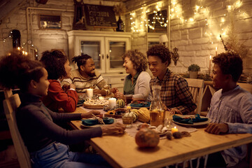 Happy black multigeneration family having dinner at dining table on Thanksgiving.