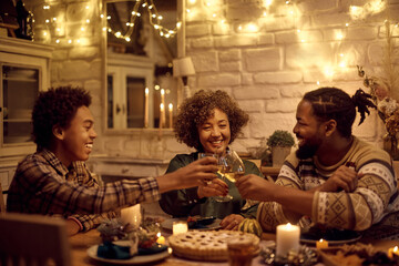 Happy African American extended family toasting during Thanksgiving dinner at dining table.