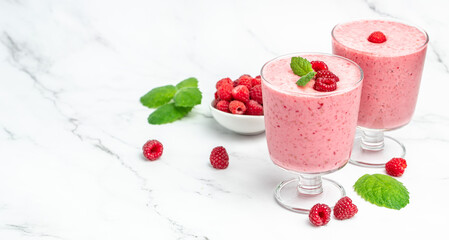 raspberries smoothie milkshake or yogurt in glass jar with berries. Yogurt cocktail on a white...