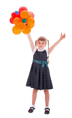 schoolgirl with balloons. Adorable little schoolgirl with a happy smile keeps her arms crossed. 