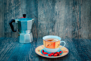 A cup of tea, rose hips and a kettle. Vitamins, disease prevention