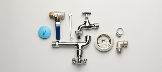 Set of plumber's items on light background, top view